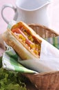 Classic hotdog with mustard and chili sauce on rattan basket